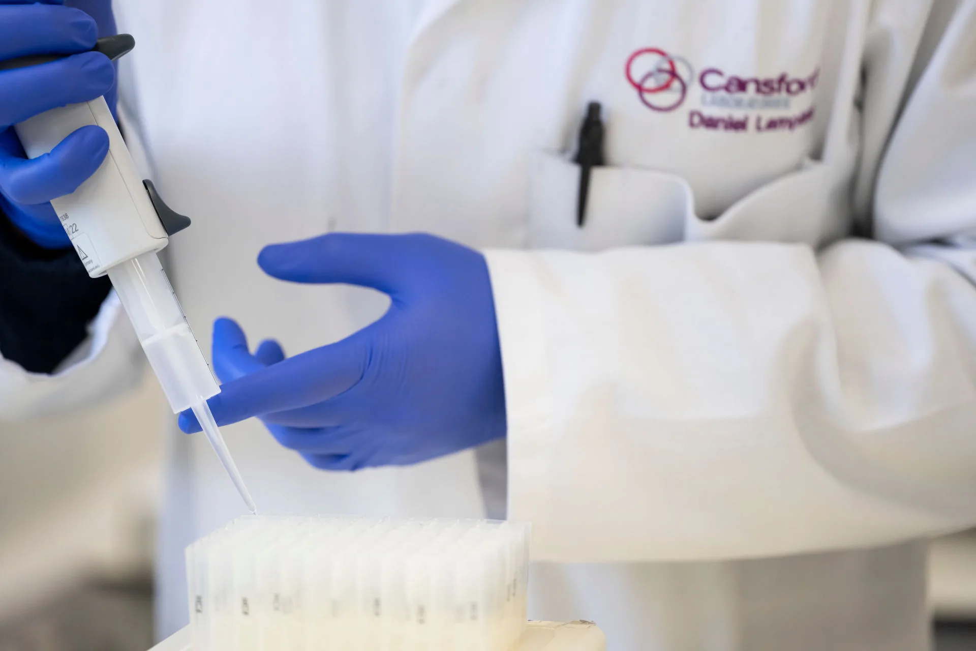 A gloved hand taking samples in a laboratory