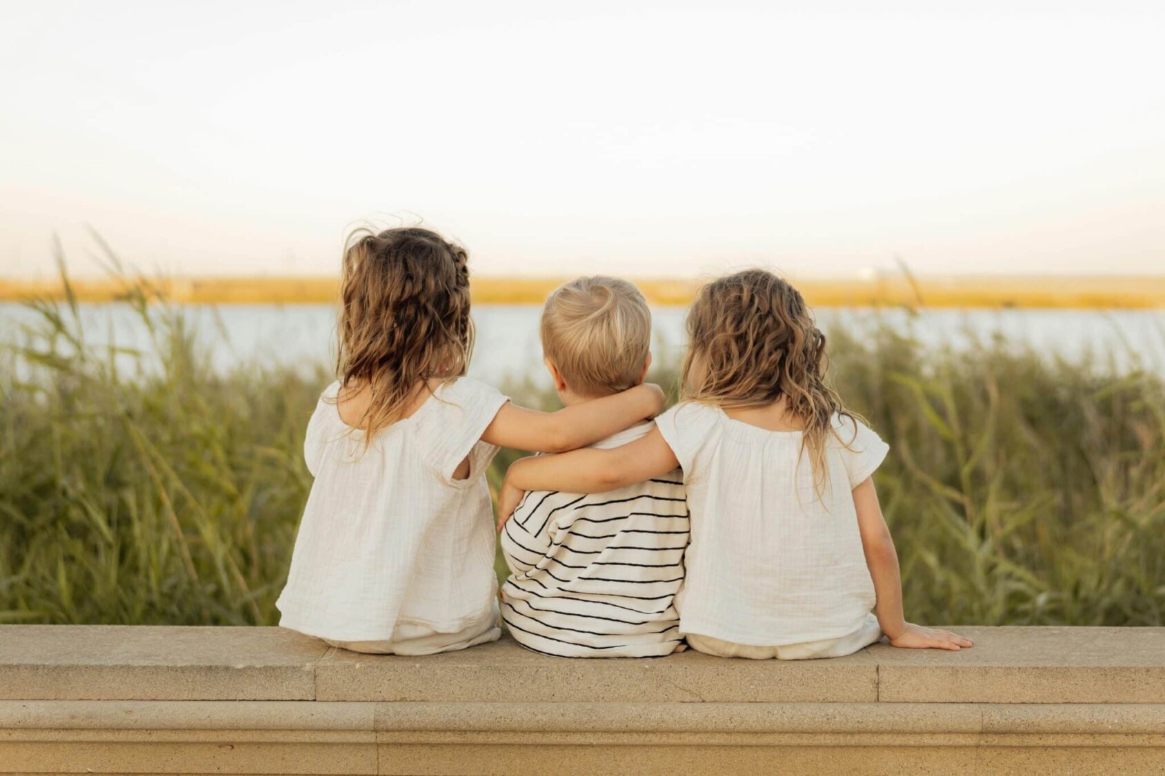 Three small children sitting with their backs to the camera