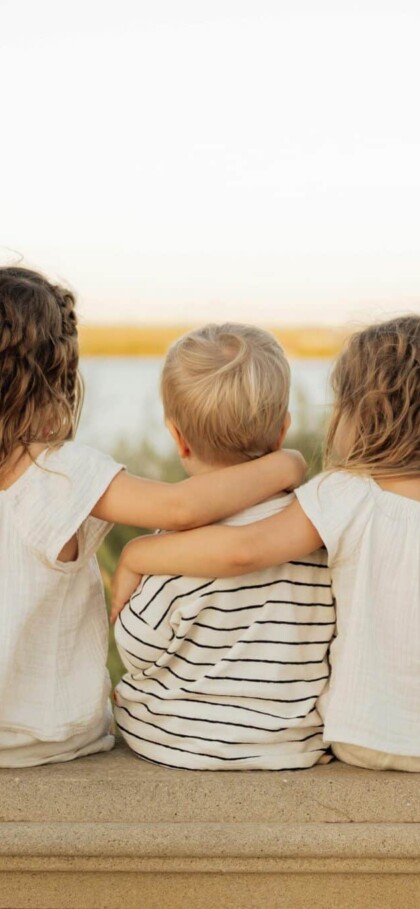 Three small children sitting with their backs to the camera