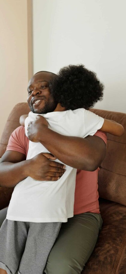 Father and son hugging with son facing away from camera