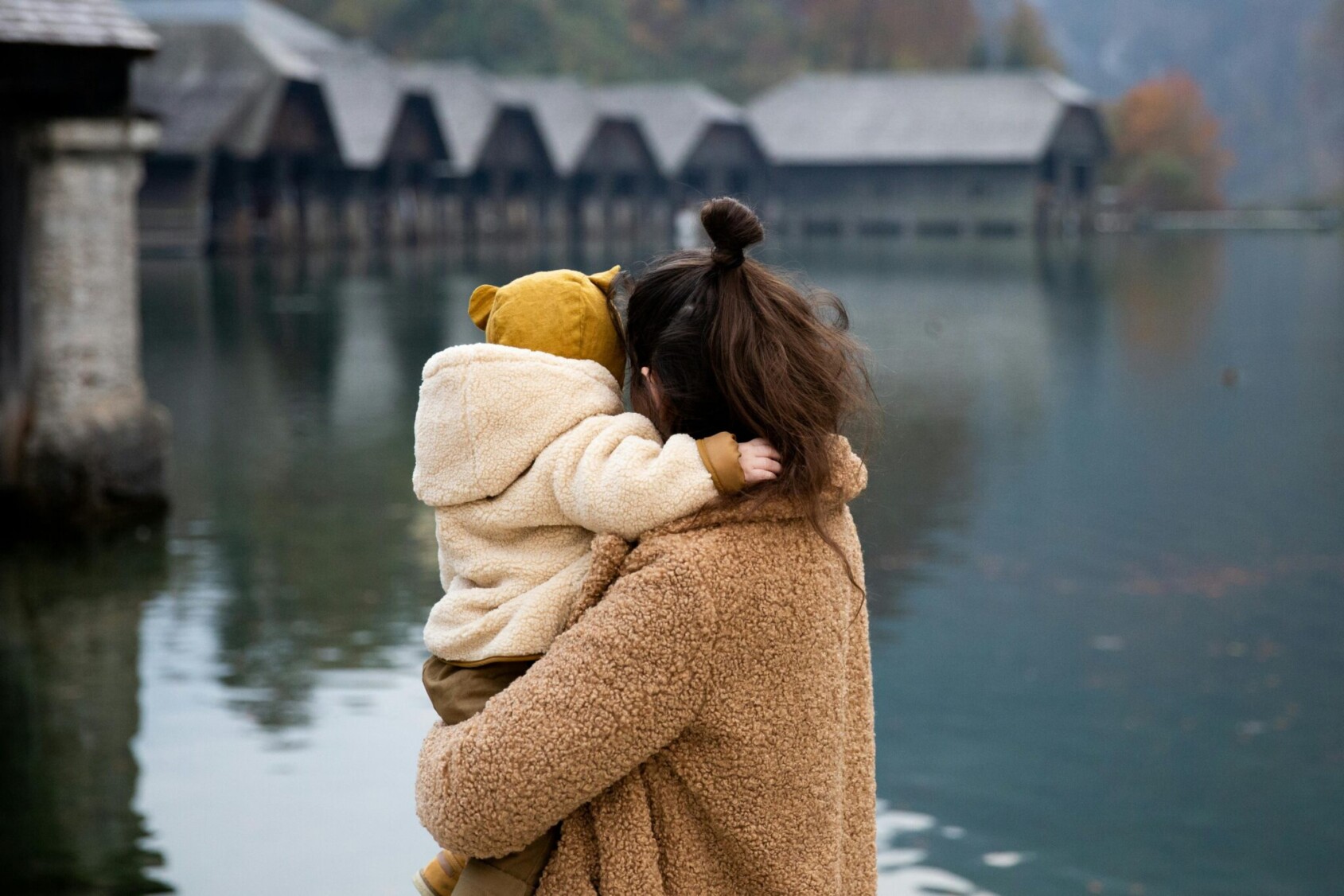 Mother holding a child and looking out over a lake